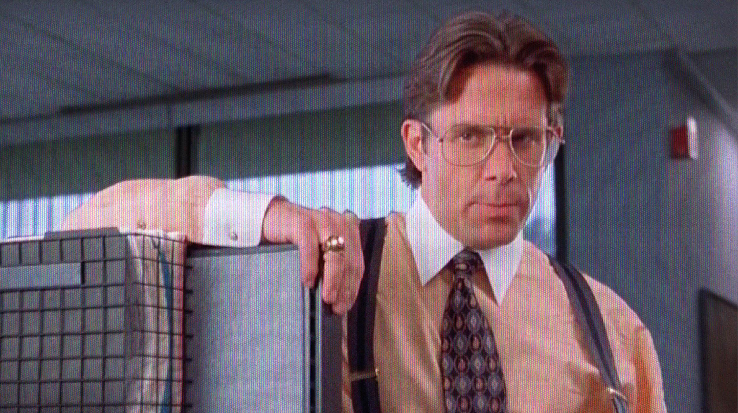 A man in a tie and suspends holding a crate.