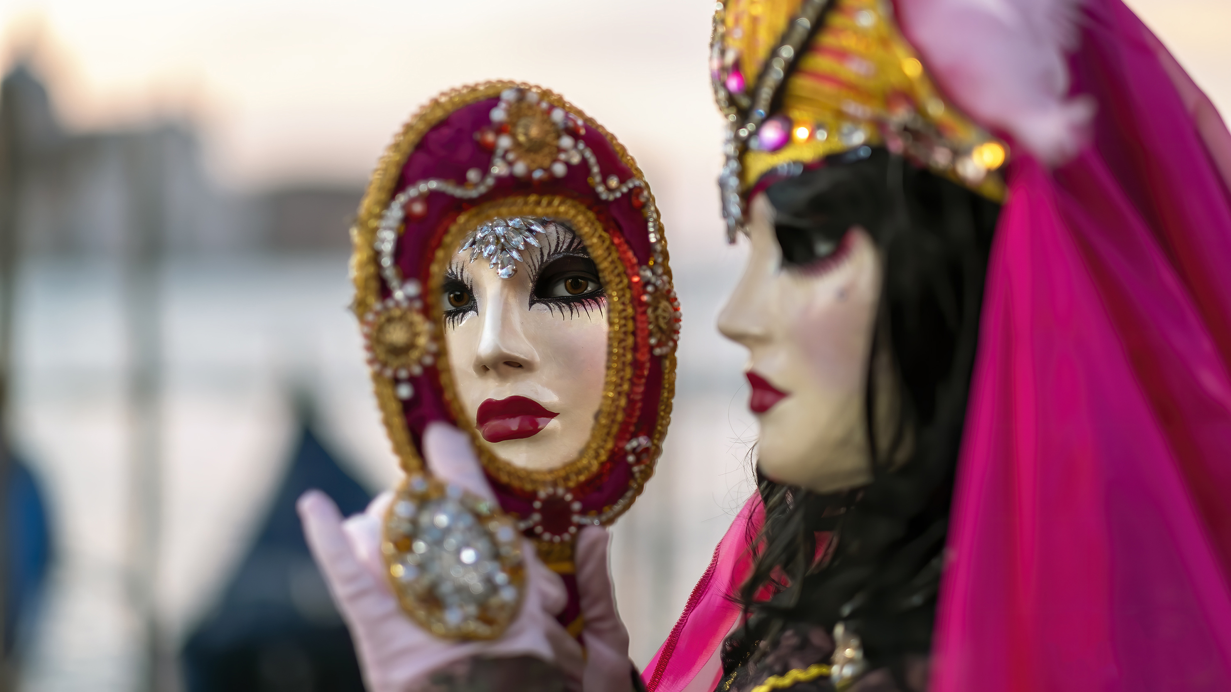 A woman in a pink mask is holding a Nietzsche mirror.
